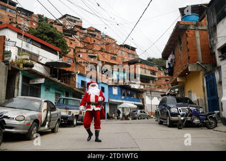 Caracas, Venezuela. 15 décembre 2023. 15 décembre 2023, Venezuela, Caracas : un homme habillé en Père Noël marche dans une ruelle dans le quartier pauvre de Petare lors de la remise de la campagne de cadeau «Un jouet, de bonnes nouvelles». Photo : Pedro Mattey/dpa crédit : dpa Picture alliance/Alamy Live News Banque D'Images