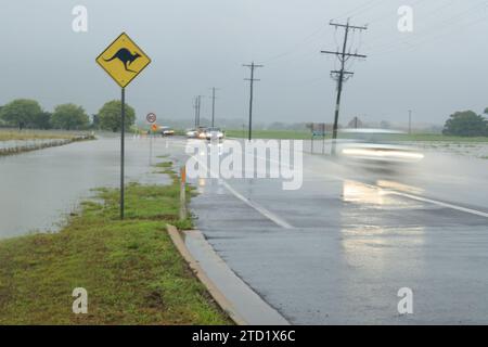 Les voitures tentent de passer une route dans la banlieue nord des plages de Holloways Beach à Cairns après le cyclone tropical Jasper. Le cyclone tropical Jasper a touché terre sur la région de Cairns en tant que système de catégorie 2 le mercredi 13 décembre, apportant des inondations généralisées, des débris et des vents puissants. Beaucoup dans l'extrême nord du Queensland connaissent les tempêtes tropicales, mais les variations de terrain et les conditions terrestres et côtières continuent d'apporter de nouveaux problèmes tels que les inondations soudaines et l'érosion. Certaines zones comme les banlieues des plages du Nord peuvent être inondées, comme c'est le cas à Holloways Beach. Banque D'Images