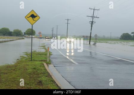 Les voitures tentent de passer une route dans la banlieue nord des plages de Holloways Beach à Cairns après le cyclone tropical Jasper. Le cyclone tropical Jasper a touché terre sur la région de Cairns en tant que système de catégorie 2 le mercredi 13 décembre, apportant des inondations généralisées, des débris et des vents puissants. Beaucoup dans l'extrême nord du Queensland connaissent les tempêtes tropicales, mais les variations de terrain et les conditions terrestres et côtières continuent d'apporter de nouveaux problèmes tels que les inondations soudaines et l'érosion. Certaines zones comme les banlieues des plages du Nord peuvent être inondées, comme c'est le cas à Holloways Beach. Banque D'Images