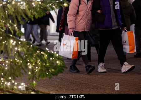 PRODUCTION - 15 décembre 2023, Rhénanie du Nord-Westphalie, Cologne : deux femmes portant des sacs dans la zone piétonne de Schildergasse. Photo : Henning Kaiser/dpa Banque D'Images