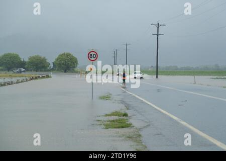 Les voitures tentent de passer une route dans la banlieue nord de Holloways Beach à Cairns à la suite du cyclone tropical Jasper. Le cyclone tropical Jasper a touché terre sur la région de Cairns en tant que système de catégorie 2 le mercredi 13 décembre, apportant des inondations généralisées, des débris et des vents puissants. Beaucoup dans l'extrême nord du Queensland connaissent les tempêtes tropicales, mais les variations de terrain et les conditions terrestres et côtières continuent d'apporter de nouveaux problèmes tels que les inondations soudaines et l'érosion. Certaines zones comme les banlieues des plages du Nord peuvent être inondées, comme c'est le cas à Holloways Beach. Banque D'Images