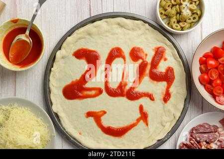 2024 écrit en pâte de tomate sur une pizza, ajoutant une touche savoureuse à la célébration du nouvel an Banque D'Images