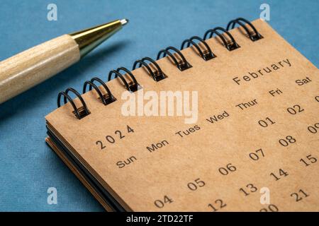 Février 2024 - calendrier de bureau en spirale contre papier texturé, temps et concept d'entreprise Banque D'Images