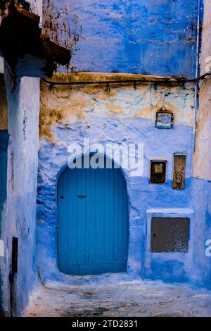 Vieille rue typique avec murs peints en bleu et portes dans la médina de Chefchaouen, Maroc Banque D'Images