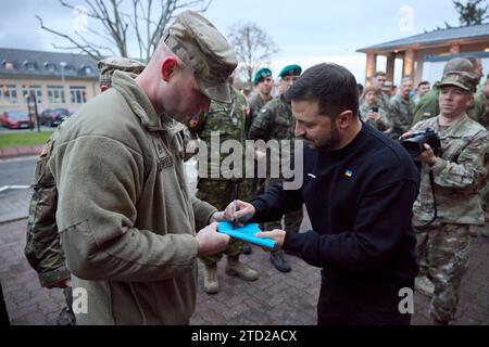 Wiesbaden, Allemagne. 14 décembre 2023. Le président ukrainien Volodymyr Zelenskyy, à droite, signe un autographe pour un soldat américain lors d'une visite au quartier général de l'armée américaine pour l'Europe et l'Afrique, le 14 décembre 2023 à Wiesbaden, en Allemagne. Crédit : Présidence ukrainienne/Bureau de presse présidentiel ukrainien/Alamy Live News Banque D'Images