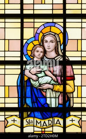 La mère de Dieu avec l'enfant Jésus. Un vitrail à l'église Saint-Laurent (église Saint-Laurent), Strassen, Luxembourg. Banque D'Images