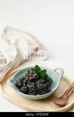 Soupe noire aux calmars ou Tumis Cumi Hitam. STIR Fried Squid à l'encre noire, cuisine traditionnelle indonésienne Banque D'Images