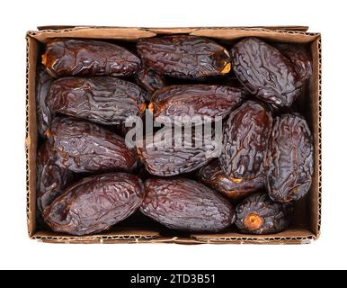 Medjool datte dans un punnet en carton. Variété cultivée de dattes séchée au soleil, grande, douce et douce, Phoenix dactylifera. Banque D'Images