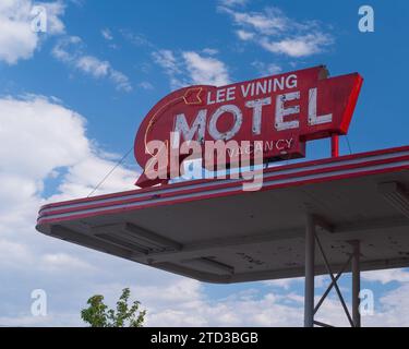 Vintage, enseigne de motel au néon montré contre un ciel bleu et des nuages. Banque D'Images