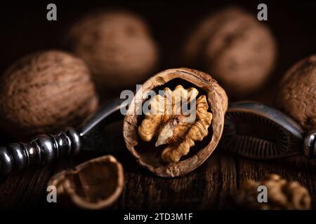 Écrou de noix ouvert avec un cracker de noix vintage en gros plan. Photographie culinaire Banque D'Images