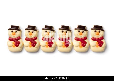 Joyeux bonhommes de neige au chocolat blanc dans une rangée sur fond blanc gros plan Banque D'Images