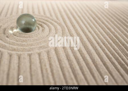 Jardin zen en sable miniature avec sphère de verre et dunes géométriques, texture abstraite Banque D'Images