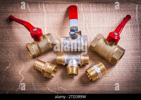 Composition des outils de plomberie raccords de tuyauterie en laiton sur le panneau en bois Banque D'Images