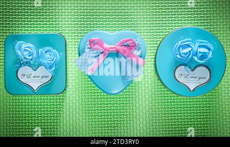 Composition de boîtes de cadeau bleu en métal emballées sur le concept de vacances de fond vert Banque D'Images