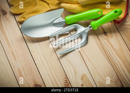 Pelle à main et fourchette avec des gants sur bois. outils de jardinage Banque D'Images