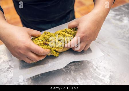 Pâte crue préparée pour le dessert Babka et placée dans un moule en métal. Pain sucré à la pistache Banque D'Images