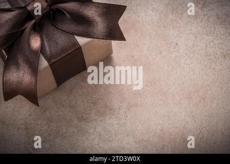 Boîte cadeau avec papier ruban marron attaché sur fond vintage Banque D'Images
