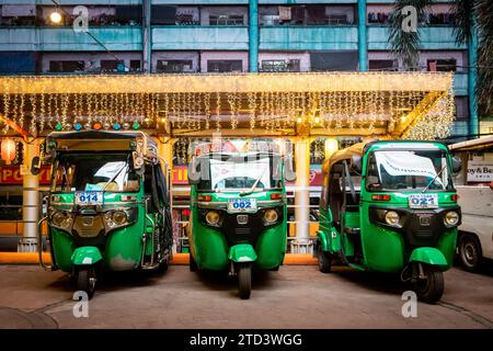 Trois élégants Tuk Tuks verts alignés à l'extérieur d'un centre commercial dans le quartier de China Town OK Manila. Banque D'Images