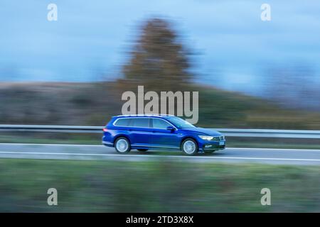 Bleu VW Passat variant conduite sur une route de campagne, crépuscule, flou de mouvement, Baden-Wuerttemberg, Allemagne Banque D'Images