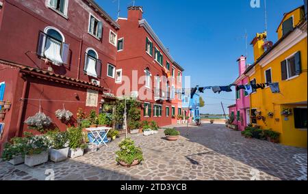 Maisons colorées avec fleurs et corde à linge, façades colorées, ruelles sur l'île de Burano, Venise, Vénétie, Italie Banque D'Images