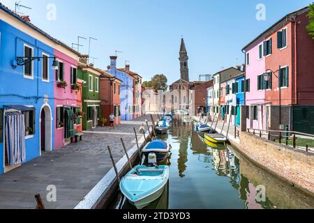 Maisons colorées sur le canal, canal avec bateaux et façades colorées, derrière la tour de l'église de la Chiesa Parrocchiale di San Martino Banque D'Images