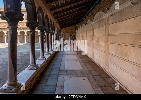 Jeune homme dans le cloître avec des tombes, église Chiesa di San Michele in Isola, cimetière île San Michele, Venise, Italie Banque D'Images