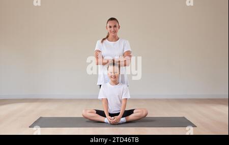 Belle enseignante pose avec une petite fille dans un cours de gymnastique. Le concept d'éducation, de sport, de Pilates, d'étirement, de mode de vie sain. Mélanger Banque D'Images