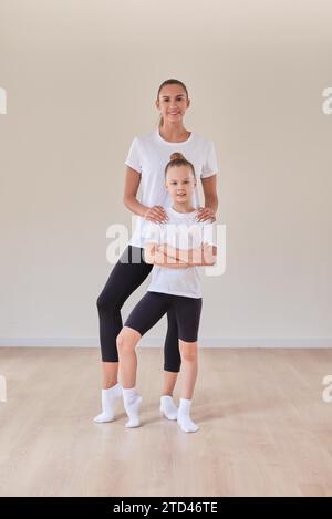 Belle enseignante pose avec une petite fille dans un cours de gymnastique. Le concept d'éducation, de sport, de Pilates, d'étirement, de mode de vie sain. Mélanger Banque D'Images