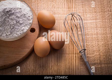 Bol avec des œufs de farine corolle sur planche de bois concept de nourriture et boisson Banque D'Images