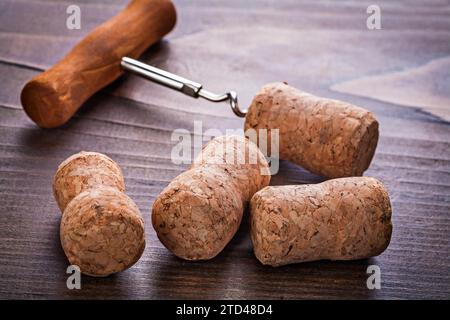 Bouchons de chmapagne et tire-bouchon sur concept d'alcool de planche en bois vintage Banque D'Images