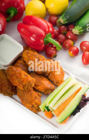 Ailes de poulet de buffle classiques servies avec du pinzimonio frais et des légumes sur fond, DE LA NOURRITURE PLUS DÉLICIEUSE SUR LE PORTFOLIO, de la photographie alimentaire Banque D'Images