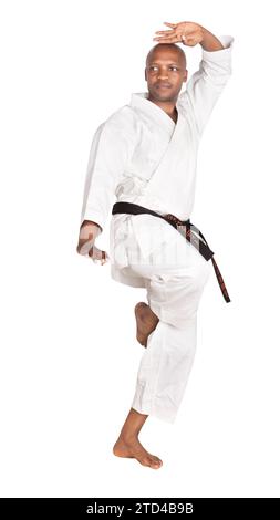 homme afro-américain dans un uniforme traditionnel de karaté blanc gi s'exerçant pour le combat, isolé sur fond blanc Banque D'Images