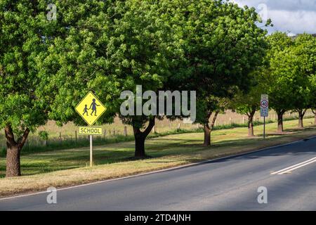 Panneau routier de zone scolaire sur une journée dans la zone rurale de Victoria, Australie Banque D'Images