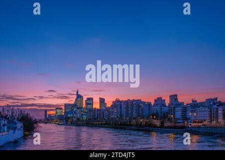 Vue lointaine des immeubles de bureaux modernes et des gratte-ciel au coucher du soleil sur une rive de la Seine dans le quartier des affaires de Paris la Défense, France Banque D'Images