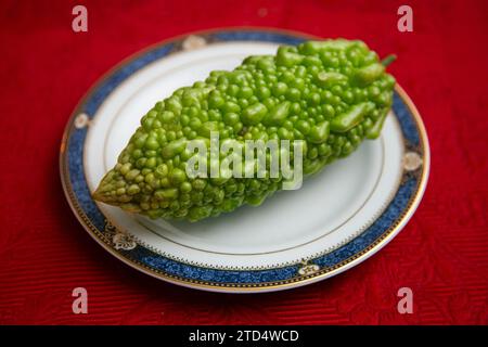 Le goya ou melon amer est un légume long et vert caractérisé par sa peau bosselée et sa saveur distincte et amère. Banque D'Images