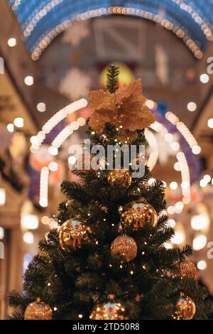 Sapin de Noël festif, décoré de lumières dorées, flocons de neige, perles. Détails magiques à l'intérieur. Banque D'Images