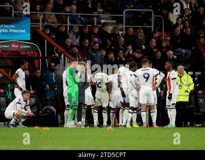 Les joueurs de Luton Town attendent sur la ligne de côté tandis que leur coéquipier Tom Lockyer reçoit un traitement sur le terrain lors du match de Premier League au Vitality Stadium, Bournemouth. Date de la photo : Samedi 16 décembre 2023. Banque D'Images