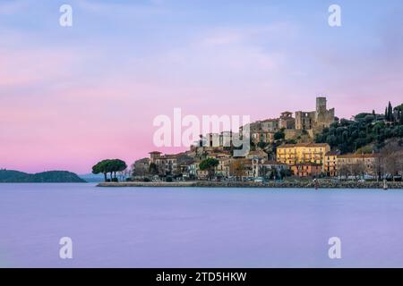 Village perché de Passignano reflété dans le lac Trasimeno, Ombrie, Italie Banque D'Images