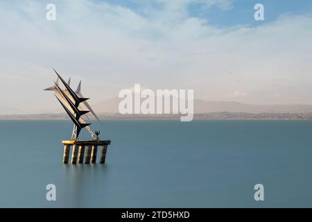 Village perché de Passignano reflété dans le lac Trasimeno, Ombrie, Italie Banque D'Images