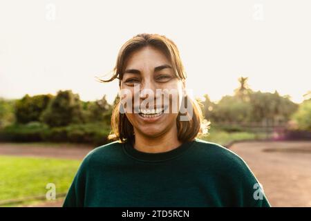 Heureuse femme latine s'amusant souriant dans la caméra dans un parc public Banque D'Images