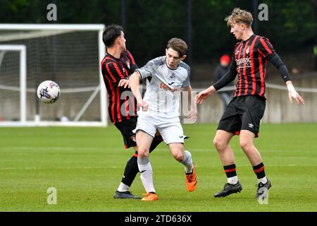 Landore, Swansea, pays de Galles. 16 décembre 2023. Harlan Perry de Swansea City se bat pour la possession de deux joueurs de l'AFC Bournemouth lors du match de la Ligue de développement professionnel des moins de 18 ans entre Swansea City et l'AFC Bournemouth à la Swansea City Academy à Landore, Swansea, pays de Galles, Royaume-Uni le 16 décembre 2023. Crédit : Duncan Thomas/Majestic Media/Alamy Live News. Banque D'Images