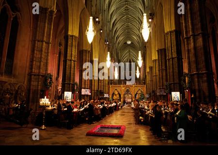 Les membres de la congrégation tiennent des bougies pendant les chants royaux - ensemble au service de Noël à l'abbaye de Westminster à Londres. Date de la photo : Vendredi 8 décembre 2023. Banque D'Images