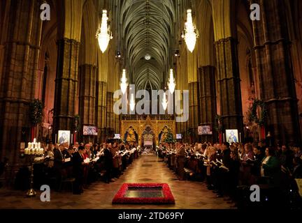 Les membres de la congrégation tiennent des bougies pendant les chants royaux - ensemble au service de Noël à l'abbaye de Westminster à Londres. Date de la photo : Vendredi 8 décembre 2023. Banque D'Images