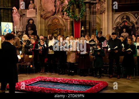 Membres de la congrégation pendant les chants royaux - ensemble au service de Noël à l'abbaye de Westminster à Londres. Date de la photo : Vendredi 8 décembre 2023. Banque D'Images