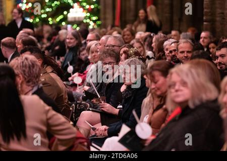 Membres de la congrégation pendant les chants royaux - ensemble au service de Noël à l'abbaye de Westminster à Londres. Date de la photo : Vendredi 8 décembre 2023. Banque D'Images