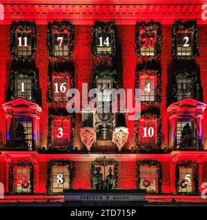 Londres, Royaume-Uni. 16 décembre 2023. Les décorations de Noël annuelles de Fortnum & Mason sont en place et montrent une fois de plus un calendrier de l'Avent géant sur la façade dans lequel chaque fenêtre représente une petite porte, comptant à rebours les jours avant Noël. Le bâtiment de Piccadilly est illuminé en rouge et attire de grandes foules touristiques. Crédit : Imageplotter/Alamy Live News Banque D'Images