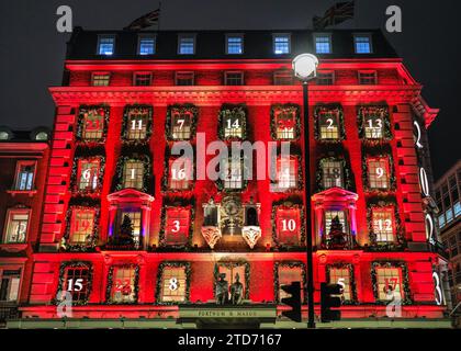 Londres, Royaume-Uni. 16 décembre 2023. Les décorations de Noël annuelles de Fortnum & Mason sont en place et montrent une fois de plus un calendrier de l'Avent géant sur la façade dans lequel chaque fenêtre représente une petite porte, comptant à rebours les jours avant Noël. Le bâtiment de Piccadilly est illuminé en rouge et attire de grandes foules touristiques. Crédit : Imageplotter/Alamy Live News Banque D'Images