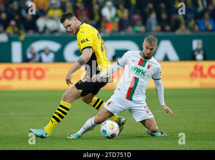 (231217) -- AUGSBOURG, 17 décembre 2023 (Xinhua) -- Niklas Suele (L) de Dortmund affronte Niklas Dorsch d'Augsbourg lors du match de football allemand de première division Bundesliga entre le FC Augsbourg et le Borussia Dortmund à Augsbourg, Allemagne, le 16 décembre 2023. (Photo de Philippe Ruiz/Xinhua) Banque D'Images