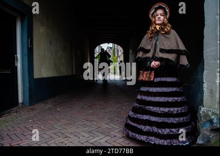 Deventer, pays-Bas . 16 décembre 2023. On voit une fille portant une robe victorienne. Chaque année, vers cette date, le monde du 19e siècle de l'écrivain anglais Charles Dickens revit dans la belle ville hollandaise de Deventer. Plus de 950 personnages des célèbres livres de Dickens remontent à la vie. Riches dames et messieurs avec des chapeaux de haut défilé dans les rues.le paysage du festival se compose de bâtiments historiques, arbres de Noël, et des milliers de petites lumières. Crédit : SOPA Images Limited/Alamy Live News Banque D'Images