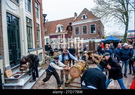 Deventer, pays-Bas . 16 décembre 2023. On voit les gens travailler le bois de manière traditionnelle. Chaque année, vers cette date, le monde du 19e siècle de l'écrivain anglais Charles Dickens revit dans la belle ville hollandaise de Deventer. Plus de 950 personnages des célèbres livres de Dickens remontent à la vie. Riches dames et messieurs avec des chapeaux de haut défilé dans les rues.le paysage du festival se compose de bâtiments historiques, arbres de Noël, et des milliers de petites lumières. Crédit : SOPA Images Limited/Alamy Live News Banque D'Images